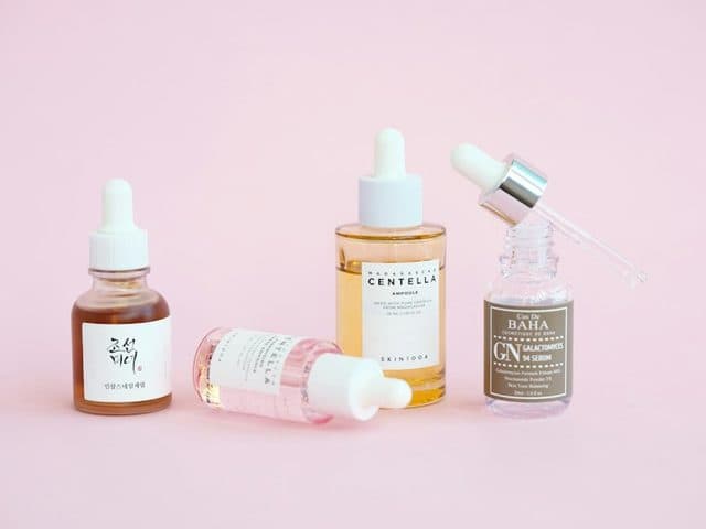 Skincare serum bottles on a pink background